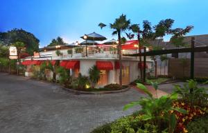 favehotel Sudirman Bojonegoro في Bojonegoro: مبنى به مظلات حمراء على شارع
