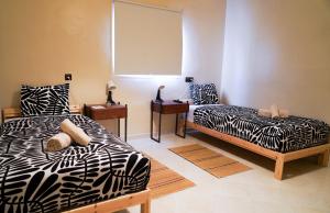 a bedroom with two beds and a window in it at Al Mohit Hôtel Dakhla in Dakhla