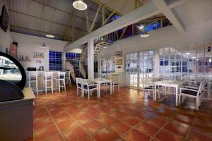 favehotel Sudirman Bojonegoro في Bojonegoro: مطعم بطاولات بيضاء وكراسي بيضاء