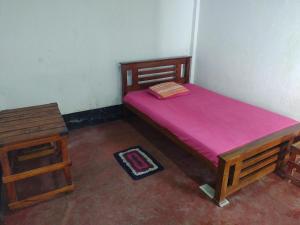 a small bedroom with a bed and a table at Great Resort in Nikawatawana +6 photos