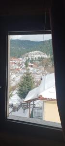 a window with a view of a snow covered city at mezonetaki in Karpenisi