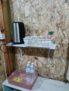 a shelf with bottles of water on a table at จรรยา โฮมสเตย์ in Chom Thong