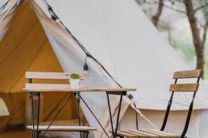 a table and two chairs in front of a tent at Secret View Glamp - La Mariposa in Alghero