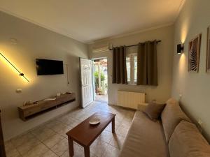 a living room with a couch and a table at Alkionis Garden View Apartments in Lefkada