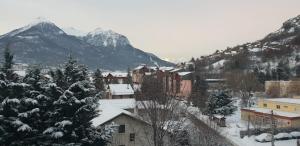 a town covered in snow with a mountain in the background at Mar Mar Appartaments in Briançon