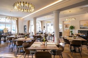 a restaurant with tables and chairs and chandeliers at Hotel Alex an der Ahr in Bad Neuenahr-Ahrweiler