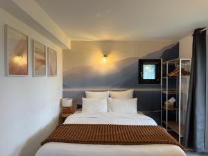 a bedroom with a large bed with white pillows at Le Chalet de la Plage in Sévrier