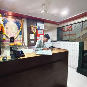 a man working at a counter in a restaurant at Sai Lodging And Boarding in Dombivli