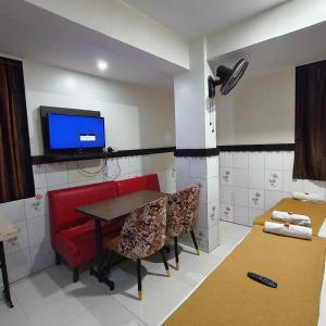 a room with a table and a tv and chairs at Sai Lodging And Boarding in Dombivli
