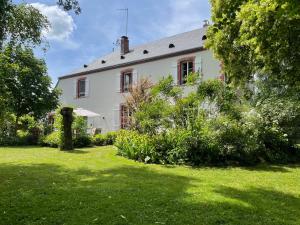 a large white house with a garden in front of it at Chez Mémé Delphine in Moutier-Malcard