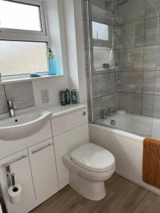 a bathroom with a sink and a toilet and a bath tub at Retreat for Two in Shepton Mallet