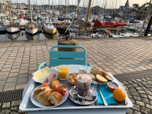Ein Tablett mit Frühstücksspeisen auf einem Tisch in der Nähe eines Jachthafens in der Unterkunft Hôtel Le Goëlo - Port de Paimpol in Paimpol + 33 Fotos