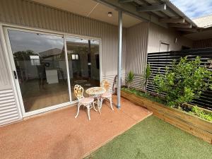 a patio with two chairs and a table on a house at Sunrise Beach Hideaway in Exmouth