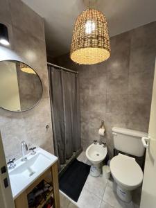 a bathroom with a sink and a toilet and a chandelier at NUEVO DPTO BANFIELD Centrico COMODO Impecable in Banfield