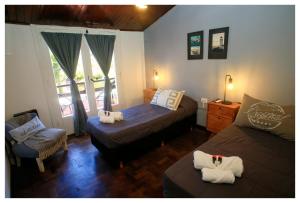 a bedroom with two beds and a chair and a window at Hotel Los Ángeles in Mar del Plata