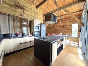 a large kitchen with a black island in a room at Grange de Marius - Authentique grange savoyarde in Albiez-Montrond