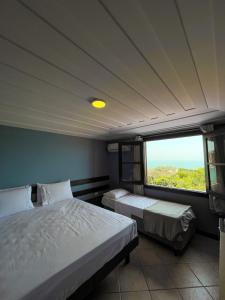 a bedroom with two beds and a large window at Pousada Mirante dos Papagaios in Búzios +61 photos