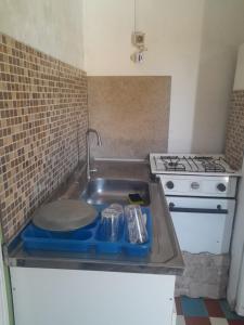 a kitchen with a sink and a stove at Canela in Atlántida