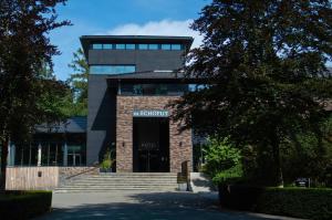 an office building with stairs leading to the entrance at Hotel Gastronomique de Echoput in Apeldoorn