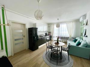 a living room with a blue couch and a table at Sunny View 2BR Apartment with Terrace - near VIVO and Amethyst in Floreşti