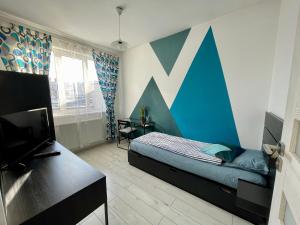 a bedroom with a bed and a blue and white wall at Sunny View 2BR Apartment with Terrace - near VIVO and Amethyst in Floreşti