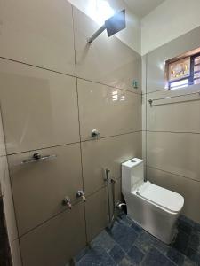 a bathroom with a toilet with a light above it at AP'S Homestay Nilambur in Nilambūr