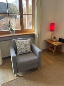 a chair sitting in a room with a window at Ferienwohnung Christensen in Murnau am Staffelsee