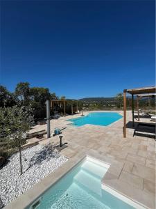 a swimming pool in the middle of a patio at Le Mas Vivarés in Lablachère