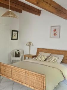 a bedroom with a large bed and a chair at La Maison Cérétane in Céret