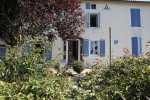 a house with blue shutters and a yard with bushes at La Maison Bleue in Rosières +8 photos