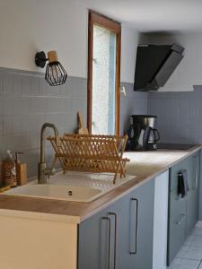a kitchen with a sink and a counter with a window at La Maison Cérétane in Céret