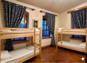 a room with three bunk beds and two windows at Vintageshvili hostel and guest house in Tbilisi City
