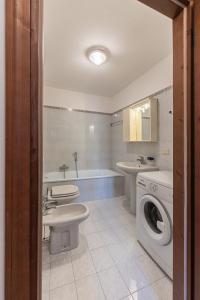 a bathroom with a toilet sink and a washing machine at Casa Tre Corone, sulla strada per Cortina in Borca di Cadore +12 photos