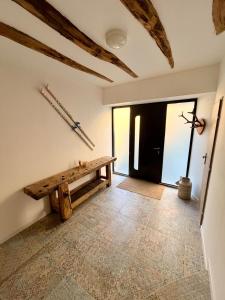 a room with a wooden bench and a door at La grange Ausar in Bareilles