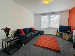 a living room with a couch and a television at Curwen Apartment - 2 Bedrooms - Sleeps 6 in Workington