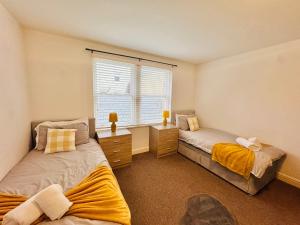 a bedroom with two beds and a window at Curwen Apartment - 2 Bedrooms - Sleeps 6 in Workington