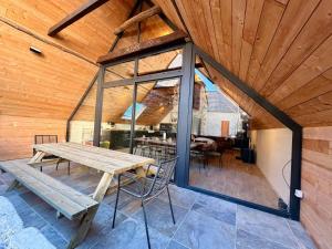 a room with a wooden ceiling and a wooden table at La grange Ausar in Bareilles