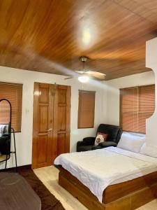 a bedroom with a bed and a wooden ceiling at Villa with Beachfront Access in Lalauigan