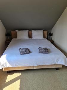 a bedroom with a bed with two towels on it at Casa Kanella Vakantiewoning in Maasmechelen