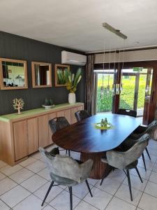 a dining room with a wooden table and chairs at Casa Kanella Vakantiewoning in Maasmechelen
