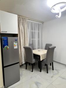 a kitchen with a table with chairs and a refrigerator at The Oceanic 42 in Durban