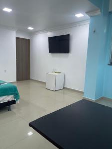 a living room with a tv on a wall at Quarto privado próximo ao centro 6 in Manaus