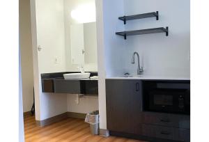 a bathroom with a sink and a mirror at Studio 6 Indianapolis, IN - Southport in Indianapolis