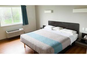 a bedroom with a bed and a window at Studio 6 Indianapolis, IN - Southport in Indianapolis