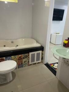 a bathroom with a tub and a toilet and a sink at Quarto privado próximo ao centro 6 in Manaus