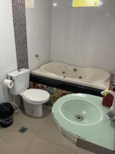 a bathroom with a tub and a toilet and a sink at Quarto privado próximo ao centro 6 in Manaus