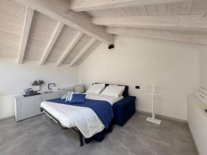 a bedroom with a blue bed in a white room at Graziosa, Casetta in Valgerola in Rasura