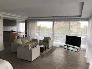 ein Wohnzimmer mit zwei Sofas und einem Fernseher in der Unterkunft Hotel Europa in Ostende