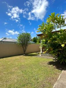 a backyard of a house with a fence at Villa Soleil des Caraïbes in Gourbeyre