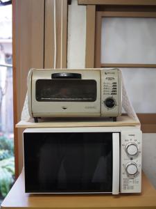 a microwave and a toaster oven sitting on a table at The Asagiri Guest House in Tanabe